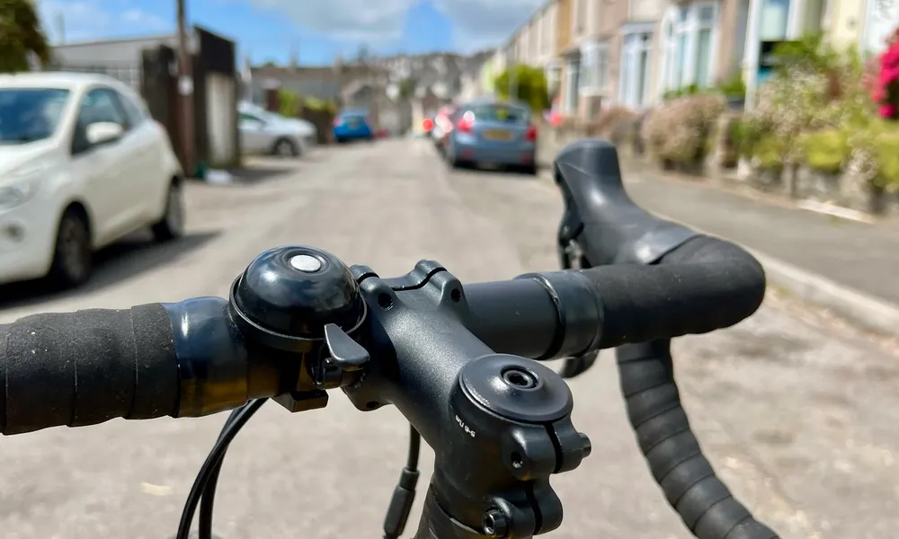 Bell on road bike handlebar on the street in summer