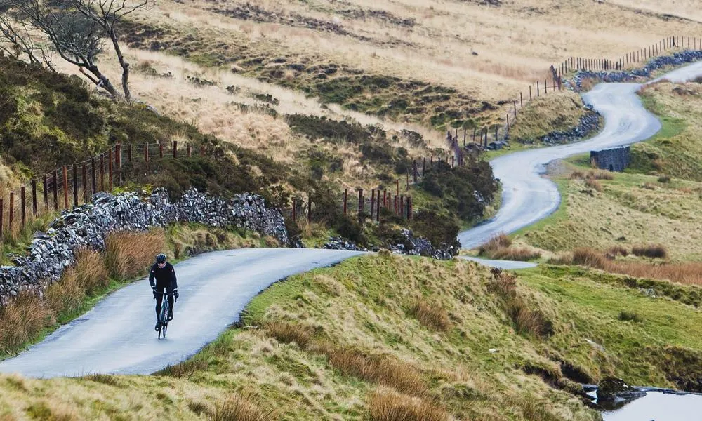 road cyclist riding along a stretch of winding road on a winter day in Wales