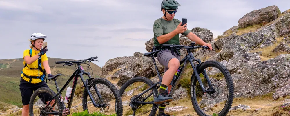 two mountain bikers using their phones