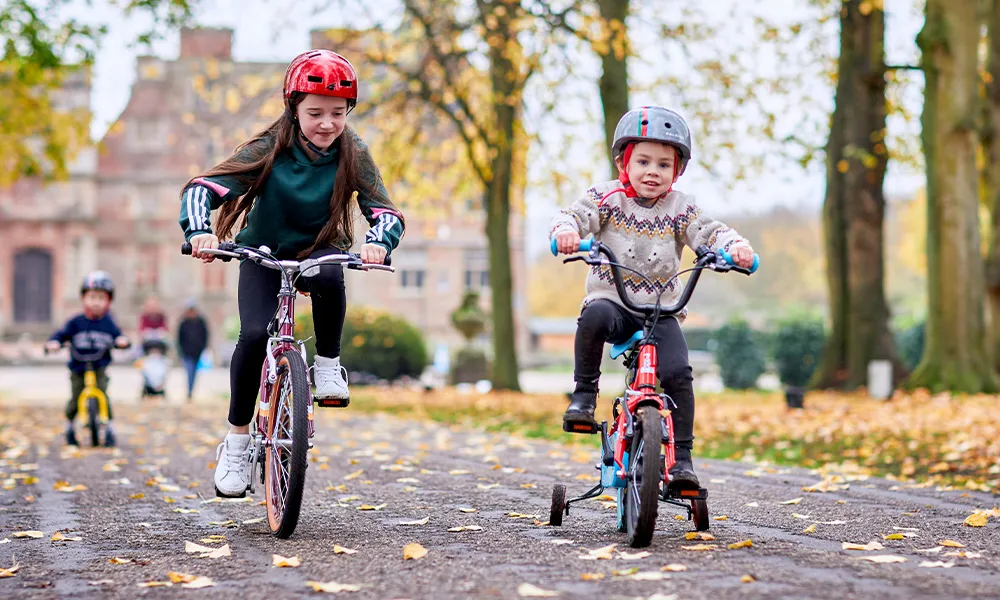 girl and boy riding kids bikes on an autumn day