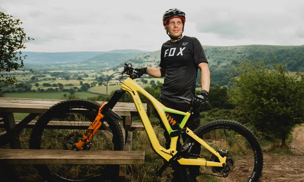 MTB rider in a short cleave jersey next to his bike