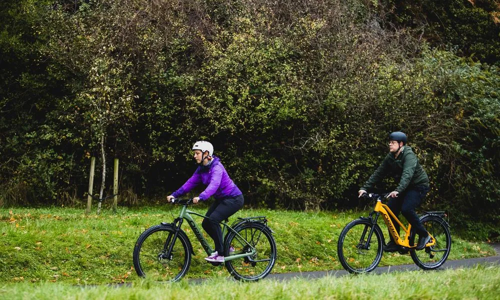 Two orbea bikes riding on a path