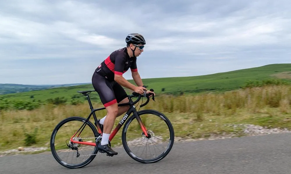 road cyclist climbing on a Tifosi road bike in the Welsh hills