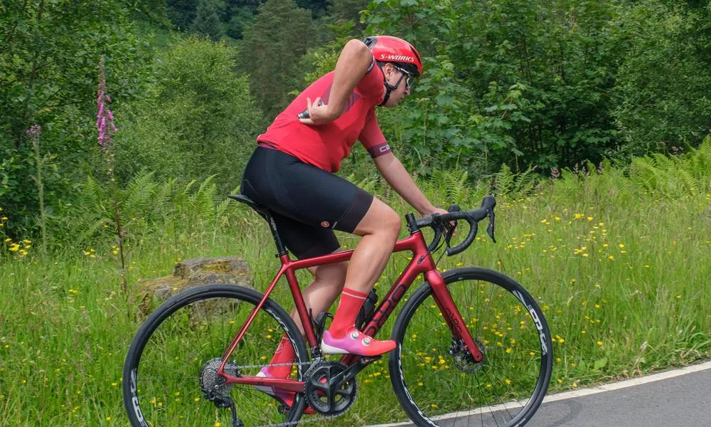 cyclist reaching for an energy gel while they ride