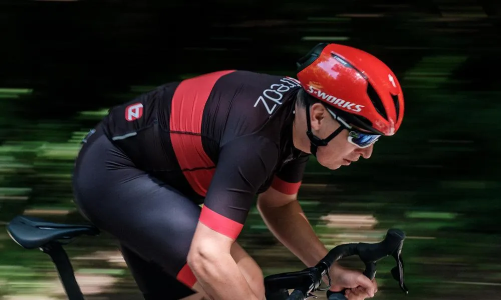 Road cyclist riding fast in a specialized helmet red