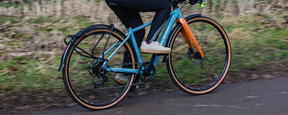 riding a hybrid e-bike with mudguards and rear rack