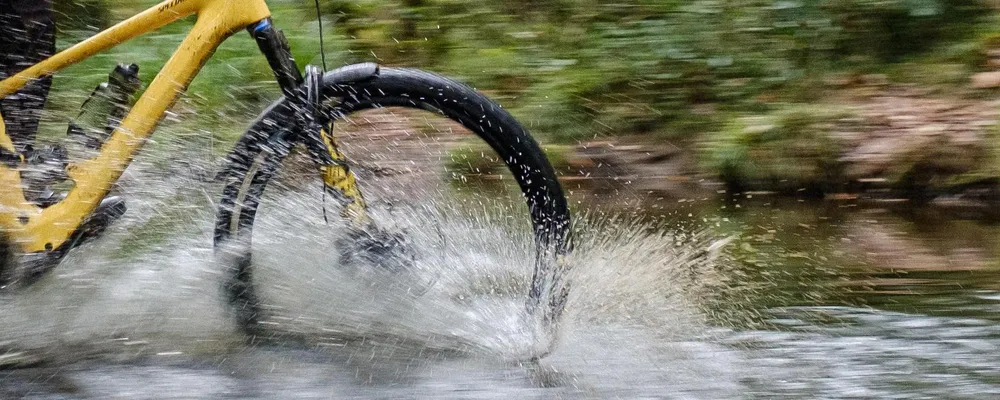 riding through a river on an e-bike with front mudguard