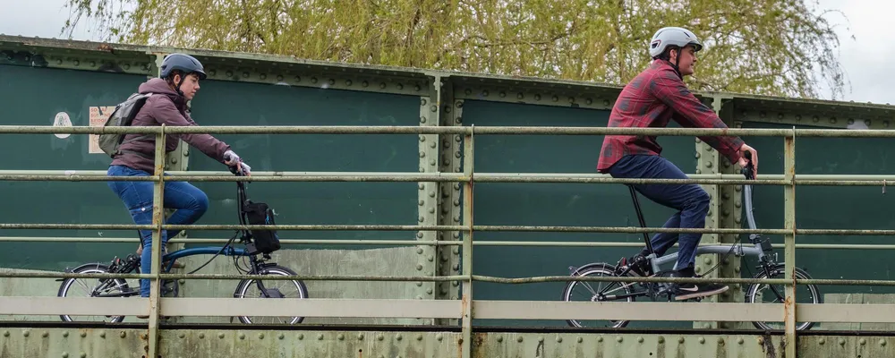 brompton folding bikes ride over a bridge