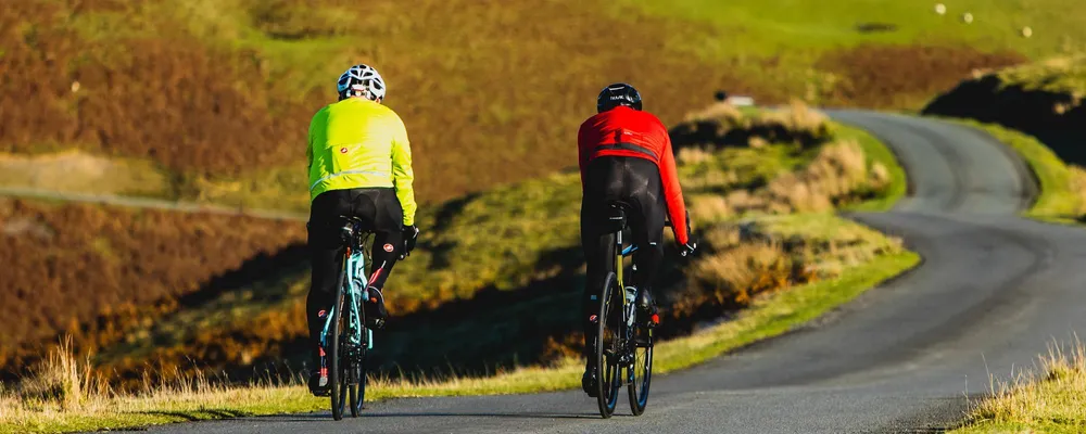 two cyclists cycling down road