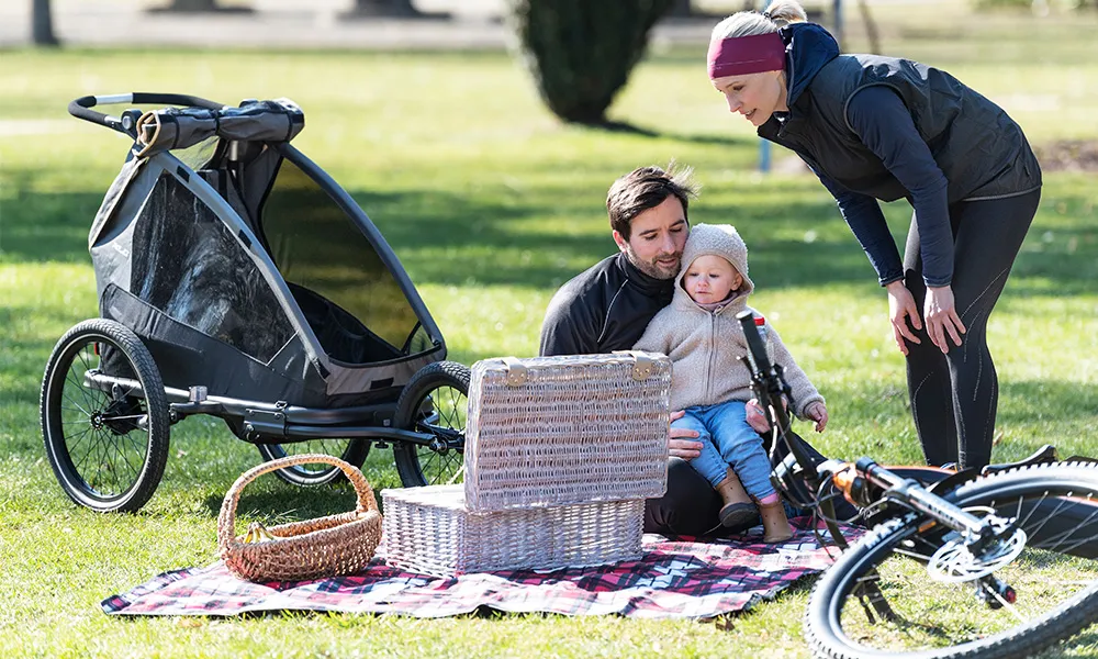 Family having a picnic with bikes adn child bike trailer