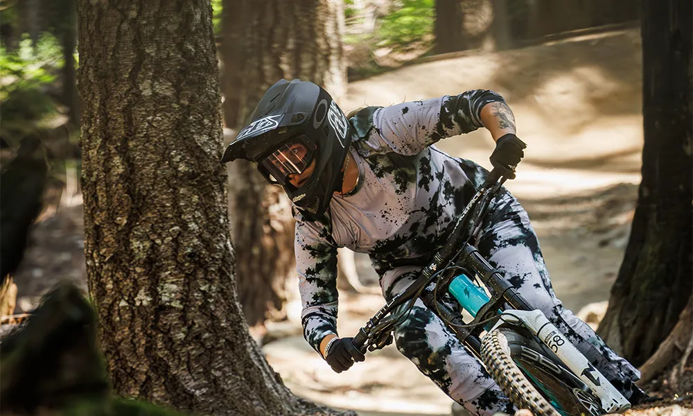 woman on downhill mountain bike wearing troy lee designs kit