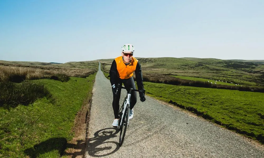 Road rider wearing an orange gilet