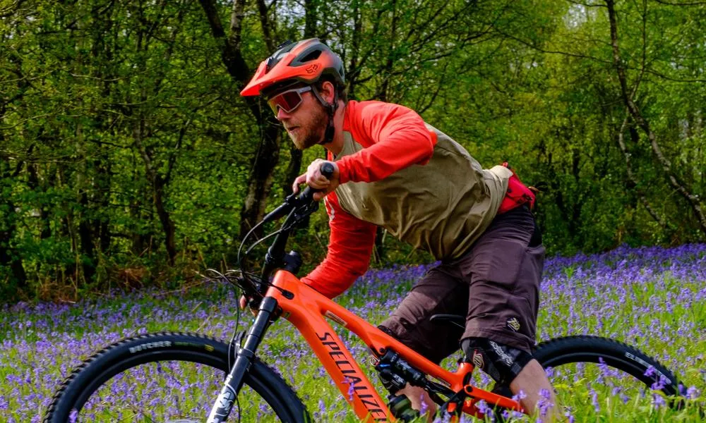 mountain biker wearing glasses on a sunny spring day close up bluebells