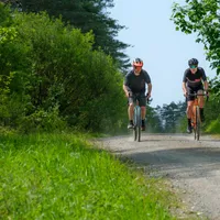 Two cyclists riding along a gravel path