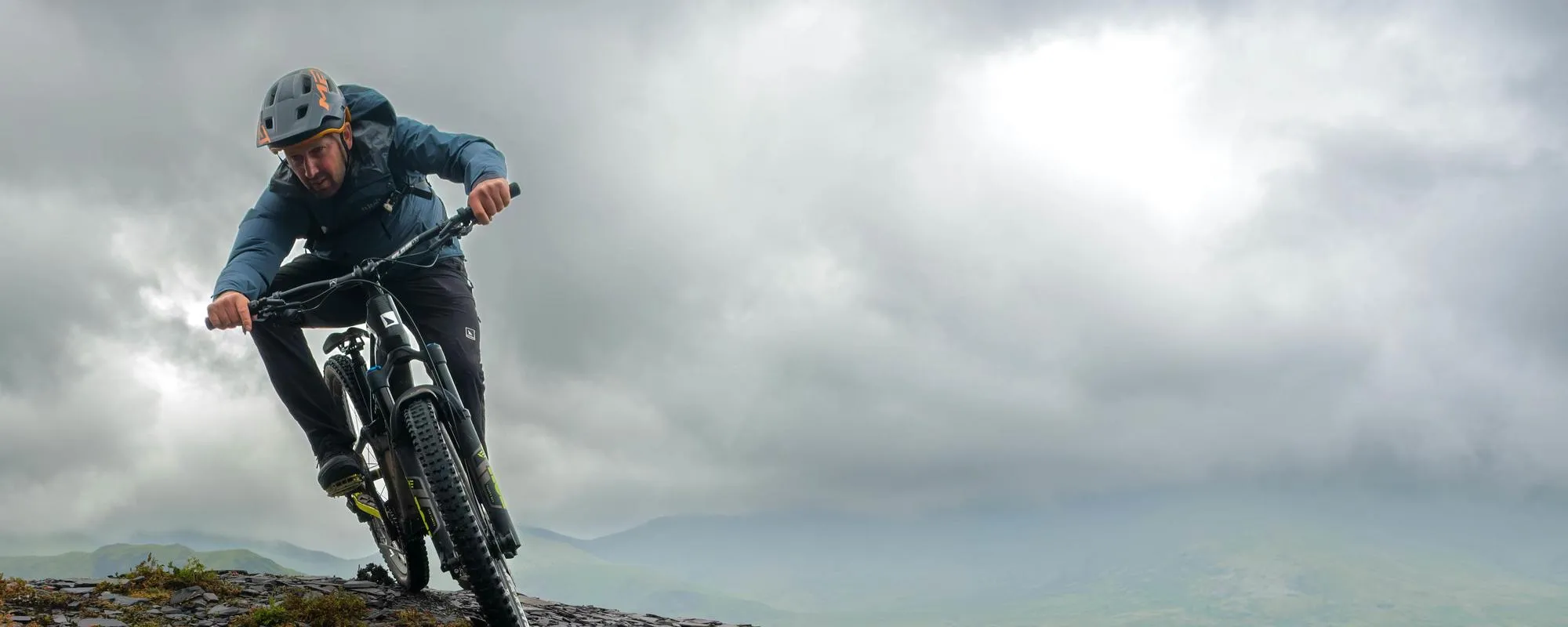 mountain biker on top of mountain in met helmet 