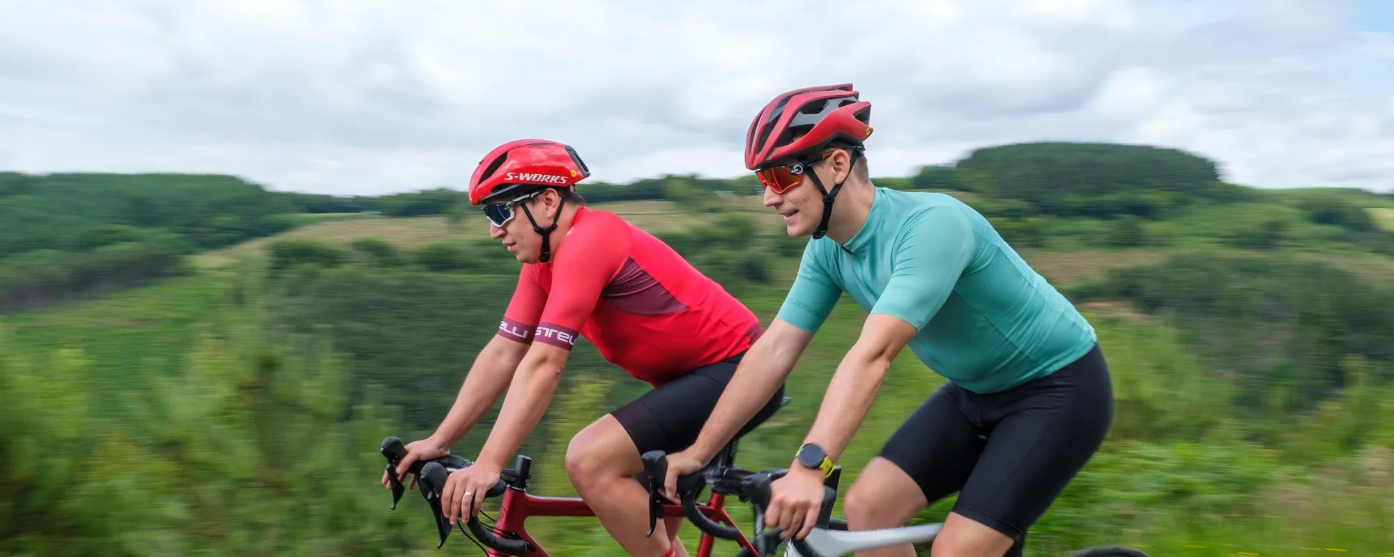 two road cyclists riding on a summer day wearing Oakly sunglasses