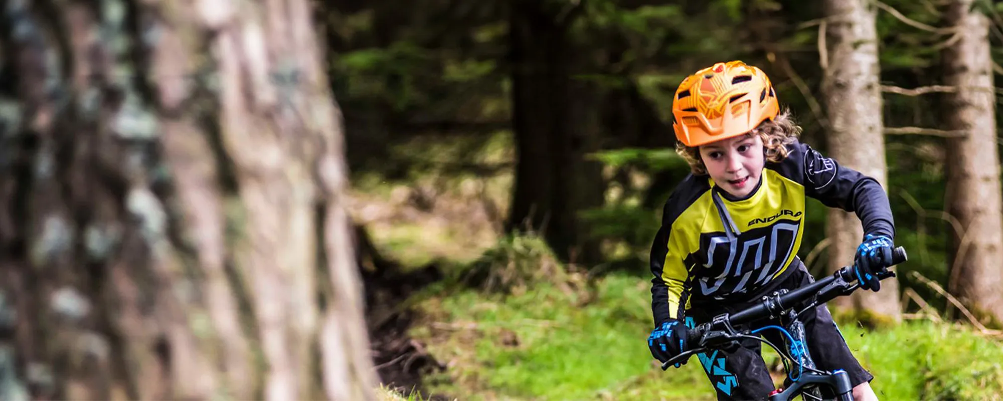 child riding a mountain bike in the woods