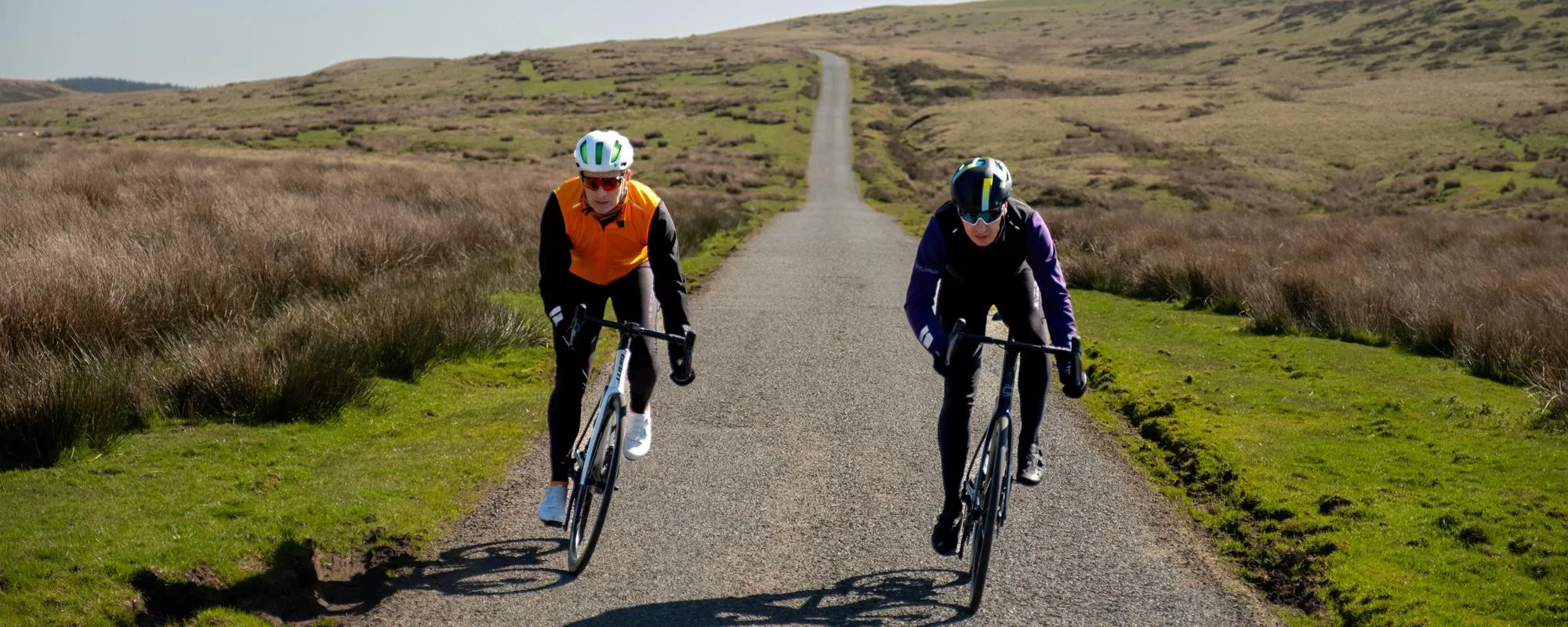 two road cyclists on long scenic road in endura kit