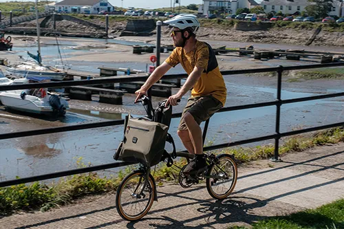 riding a brompton folding bike past a marina