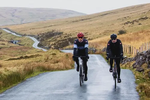 road cyclists on winding road in the rain