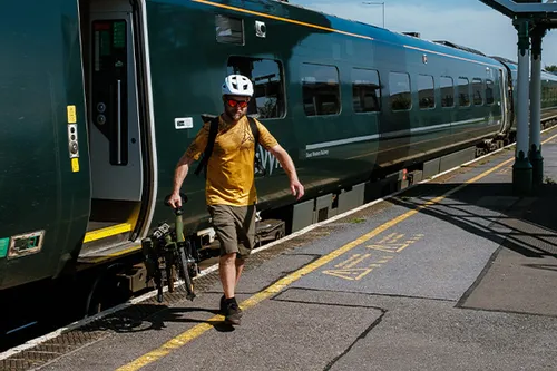 getting off a train carrying a Brompton folding bike 