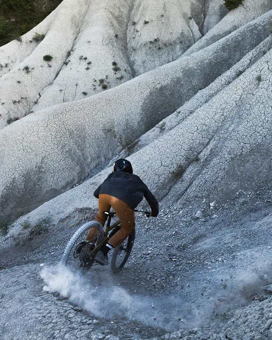 Mountain biker riding down a steep gravel shoot on a Specialized Kenevo SL e-bike