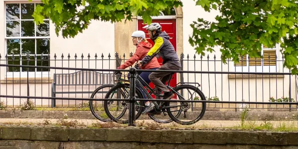 Two cycle commuters riding along a city street