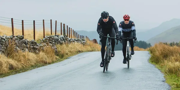 Two cyclists riding on a road in Bannau Brycheiniog