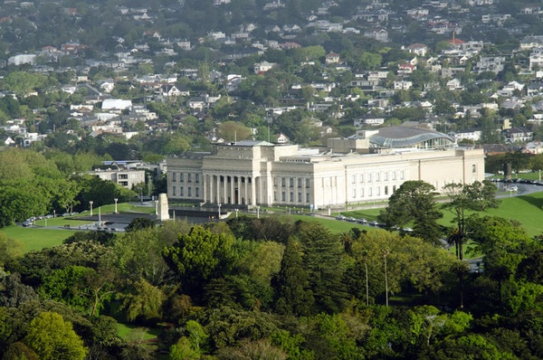 Aerial photograph of Auckland War Memorial Museum: a large, ornate white stone building at the top of a green grass hill.