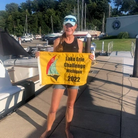 Amy holding Lake Erie Solo Challenge finish flag