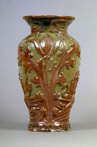 Photograph: Early twentieth century Maw and Co. vase decorated in low relief and glazed in green and brown tones. Designed by C. H. Temple in art-nouveau style.  Dated 1901.