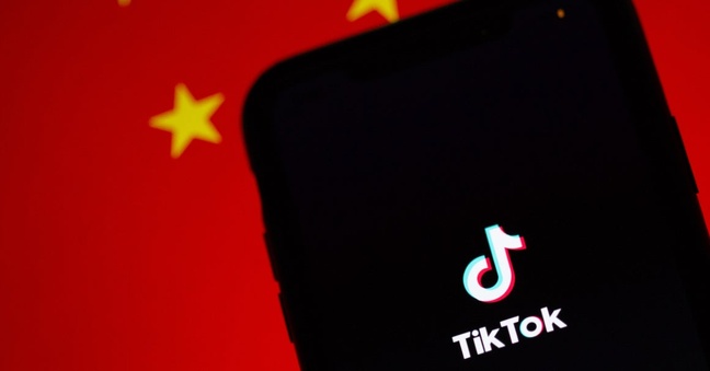 Die Tiktok-App auf einem iPhone. Im Hintergrund ist die chinesische Flagge zu sehen. Foto: Solen Feyissa/Unsplash