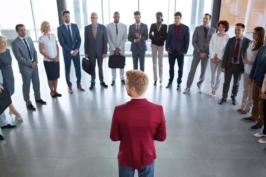 64816649 - young leader standing in front of his successful business team