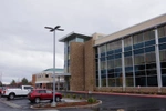 Large metal, stone, glass, and concrete medical building with cars in the parking lot