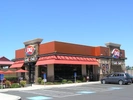 Corner view of Dairy Queen from parking lot with one car in parking lot