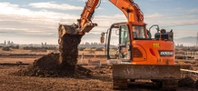 JB STEEL tractor moving dirt at Franz bakery metal building construction site. 