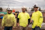 Three JB STEEL workers in dirty clothes smiling for the camera