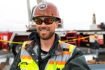 JB STEEL™ construction worker wearing sunglasses and smiling at the camera