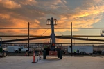 Workers at sunset building Franz Bakery steel building with large forklift