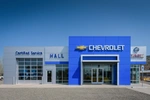 Head on view of blue and grey Chevrolet dealership with a blue sky background