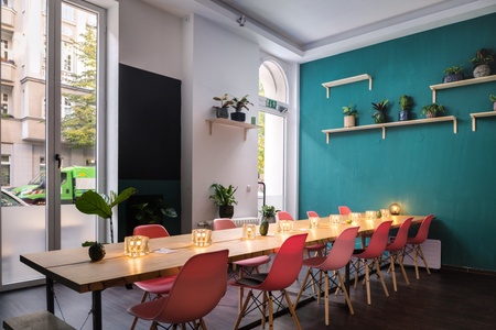 MANA Food restaurant's dinner and corporate event space in Schöneberg, Berlin. There is a table with candles on and chairs either side.
