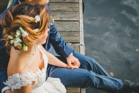 A bride and groom are sat by the river, relaxing and enjoying their vegan Berlin wedding