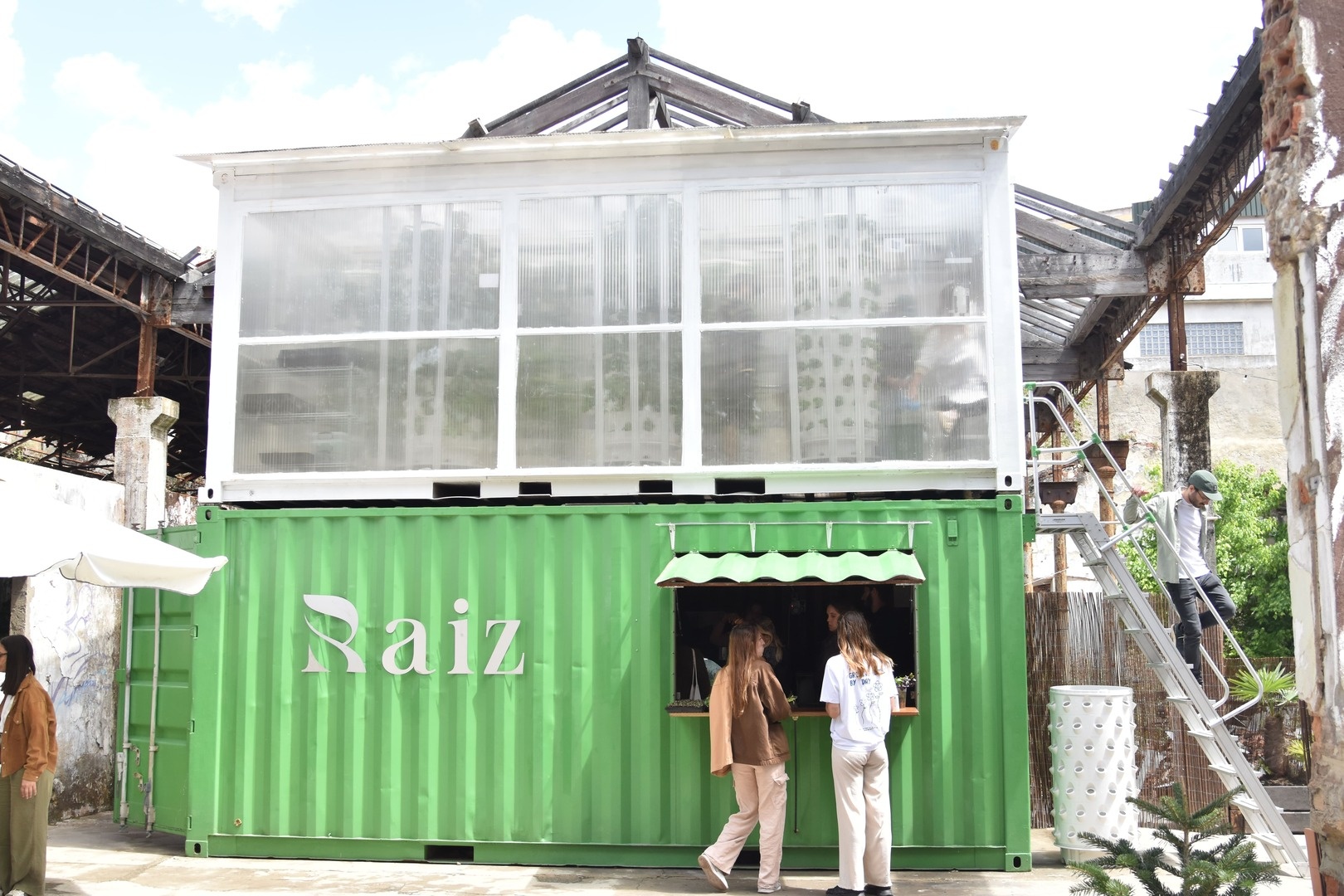 Picture of the Raiz vertical farming container with team members in Lisbon, Portugal
