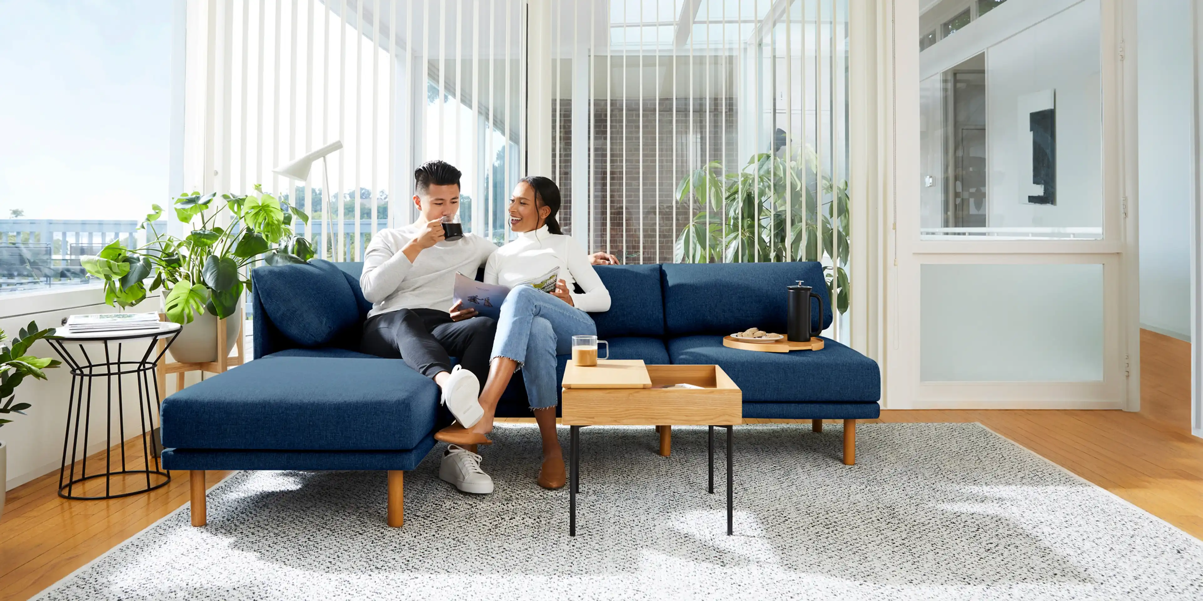 Couple sitting on a navy blue Range sofa