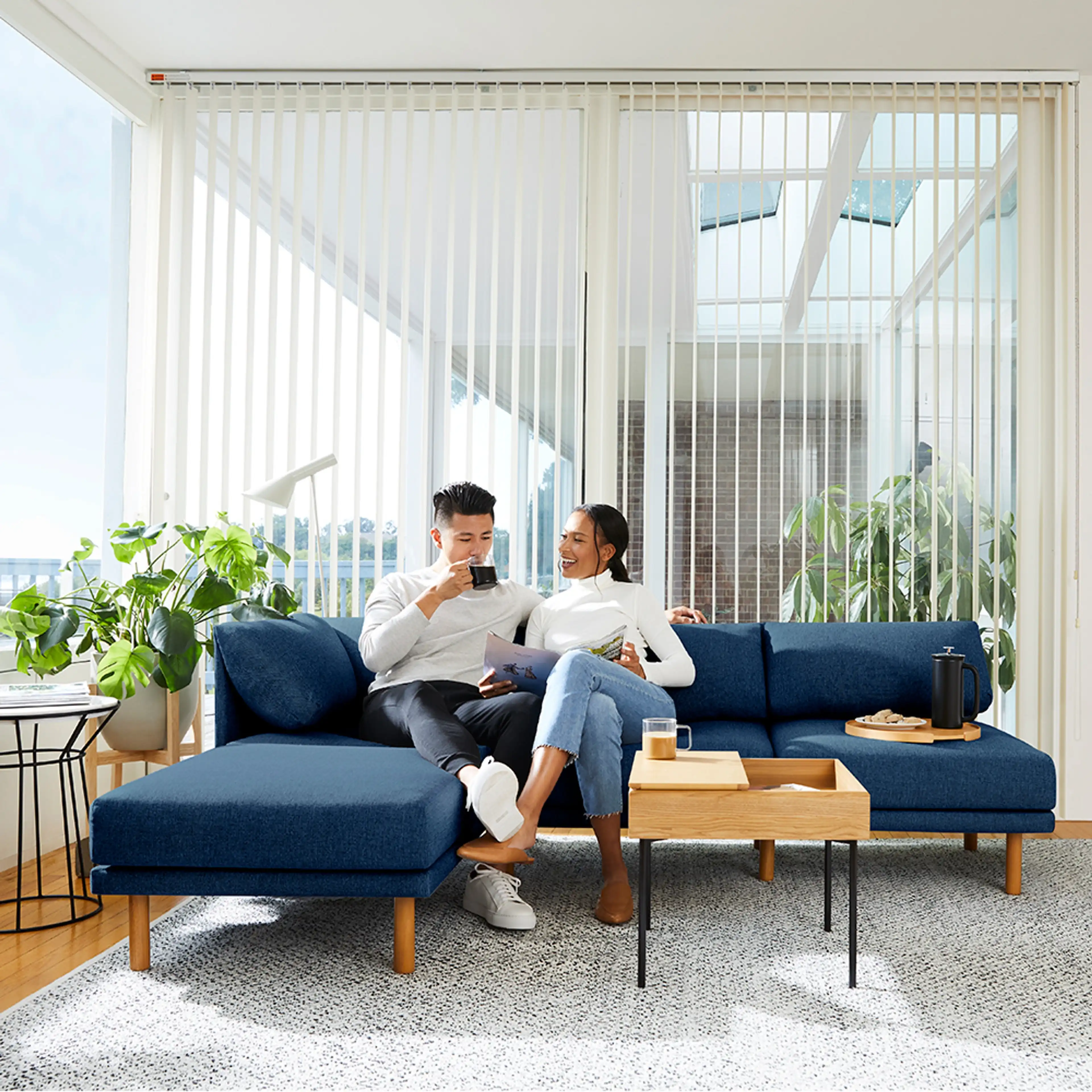 Couple sitting on a navy blue Range sofa