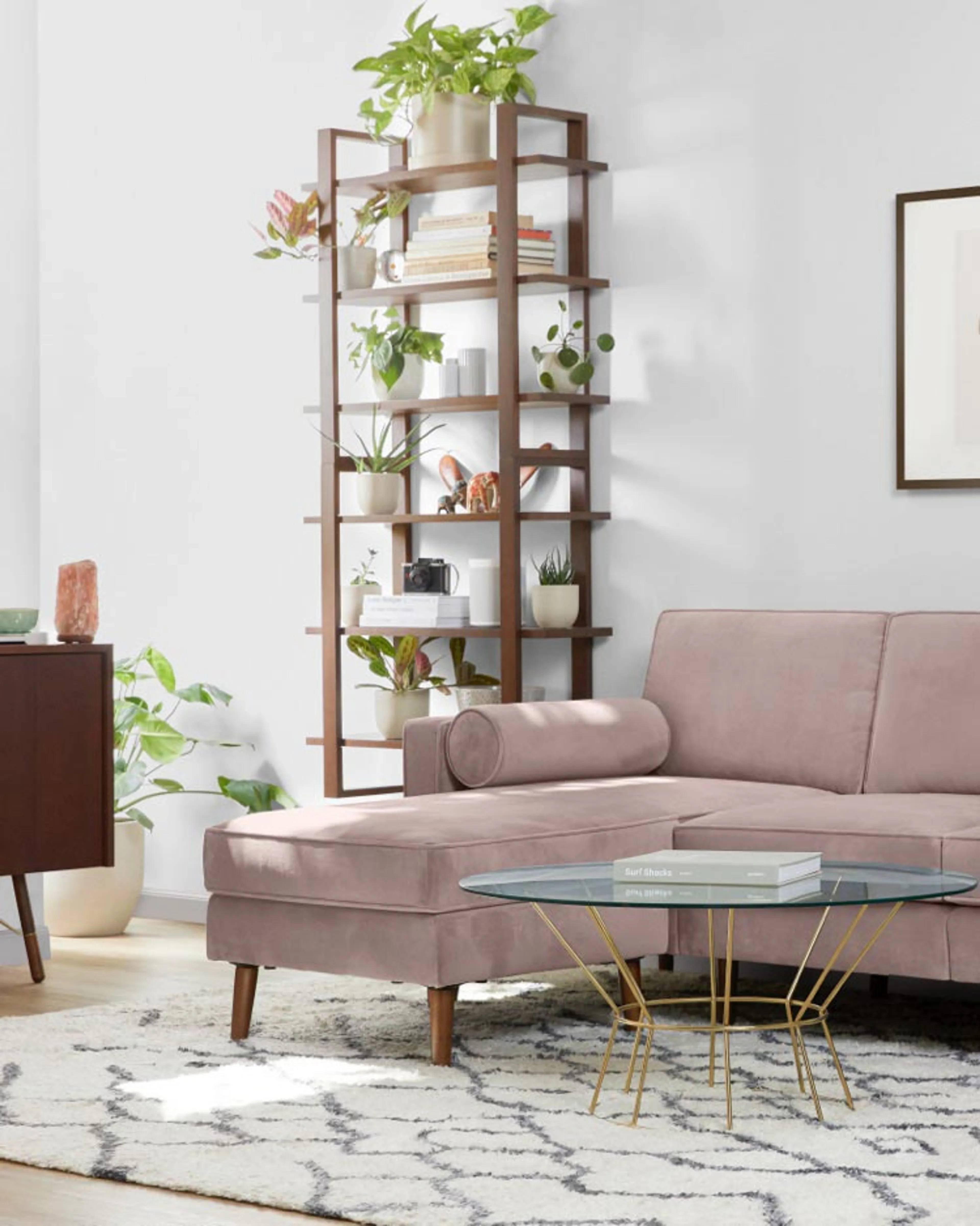 A botanical, bohemian living area, with a dusk-colored velvet sectional