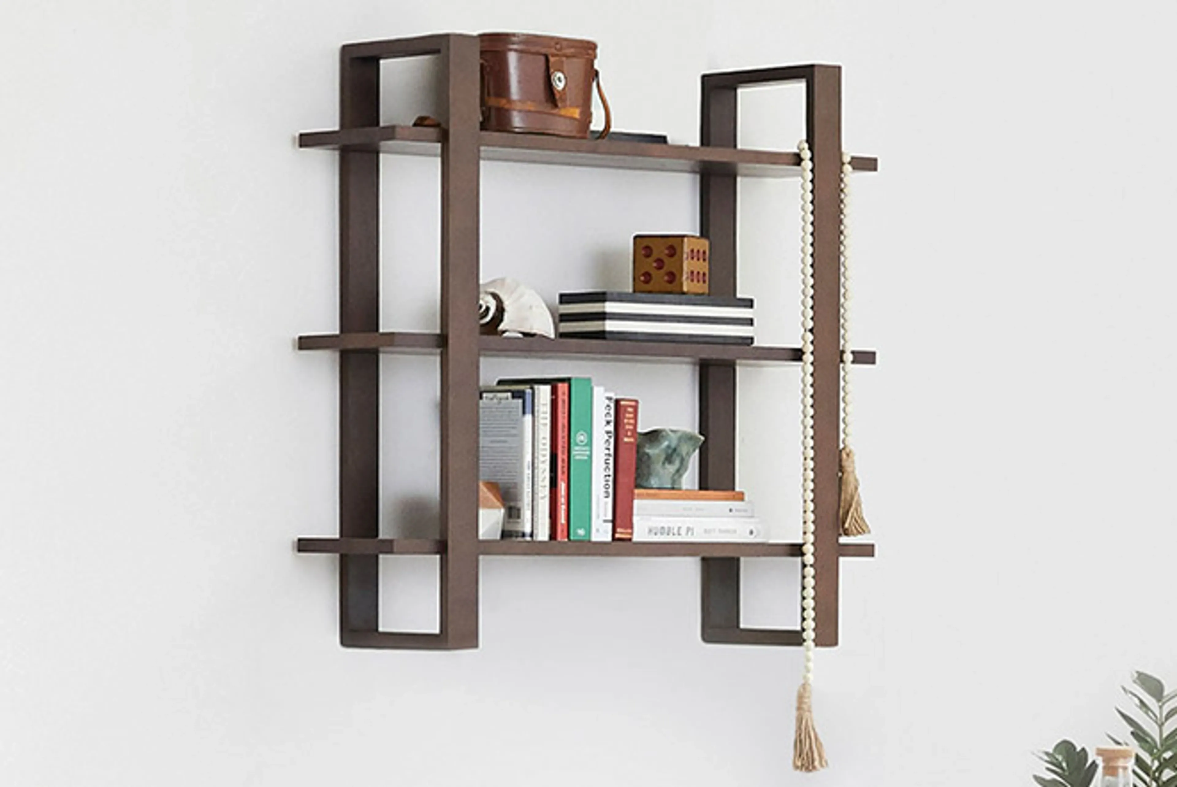 Index shelf in walnut hanging on white wall with books and decor