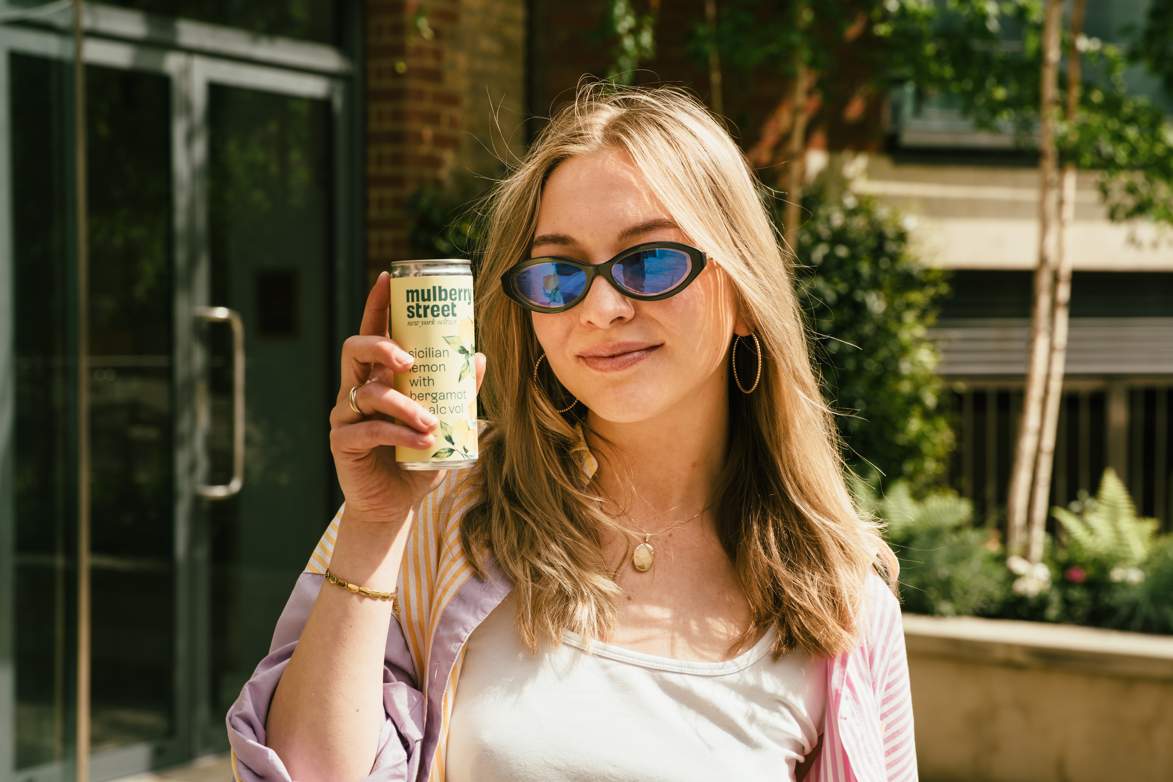 A person holding a can of Mulberry Street Lemon Seltzer