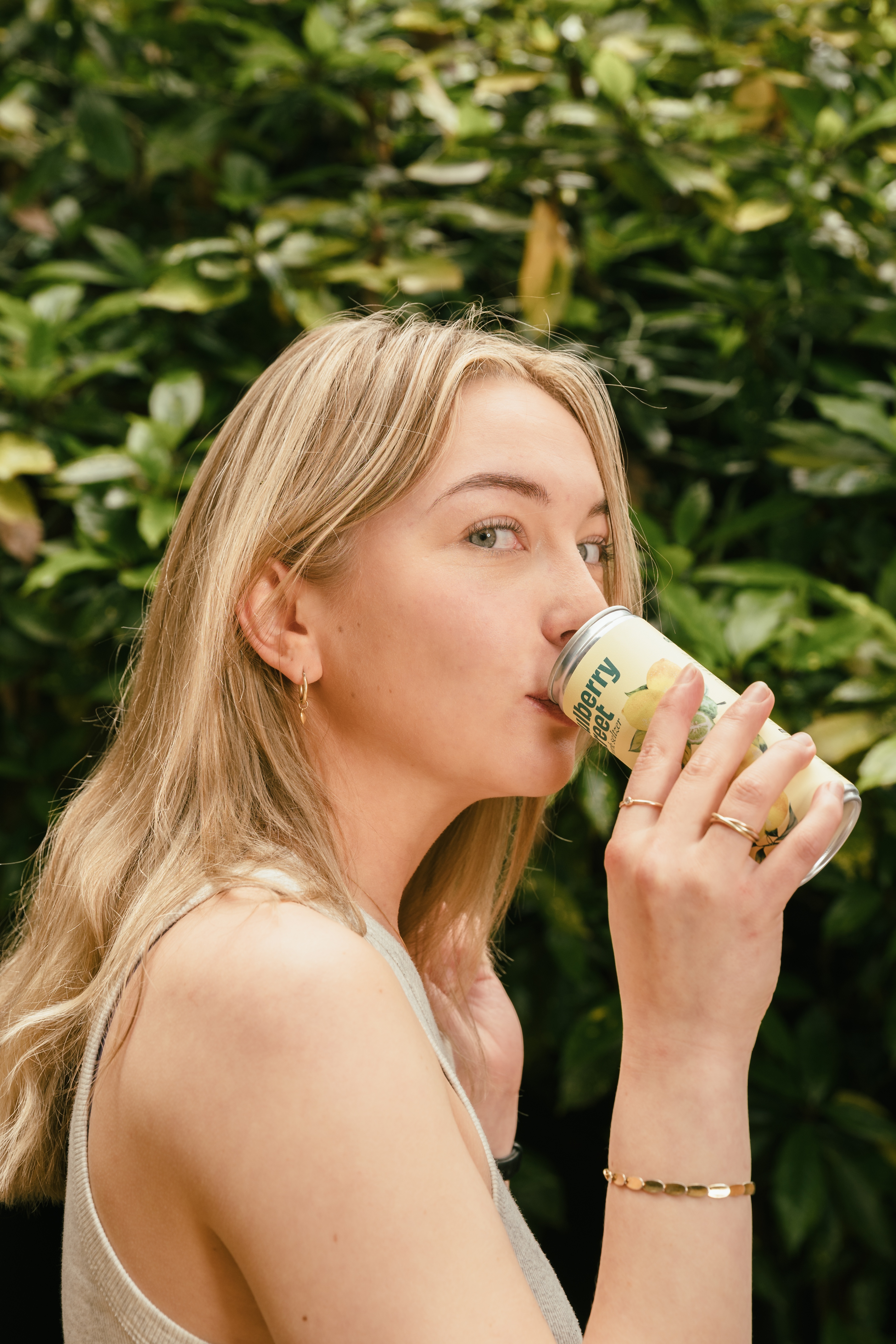 A person drinking from a can of Mulberry Street Lemon Seltzer