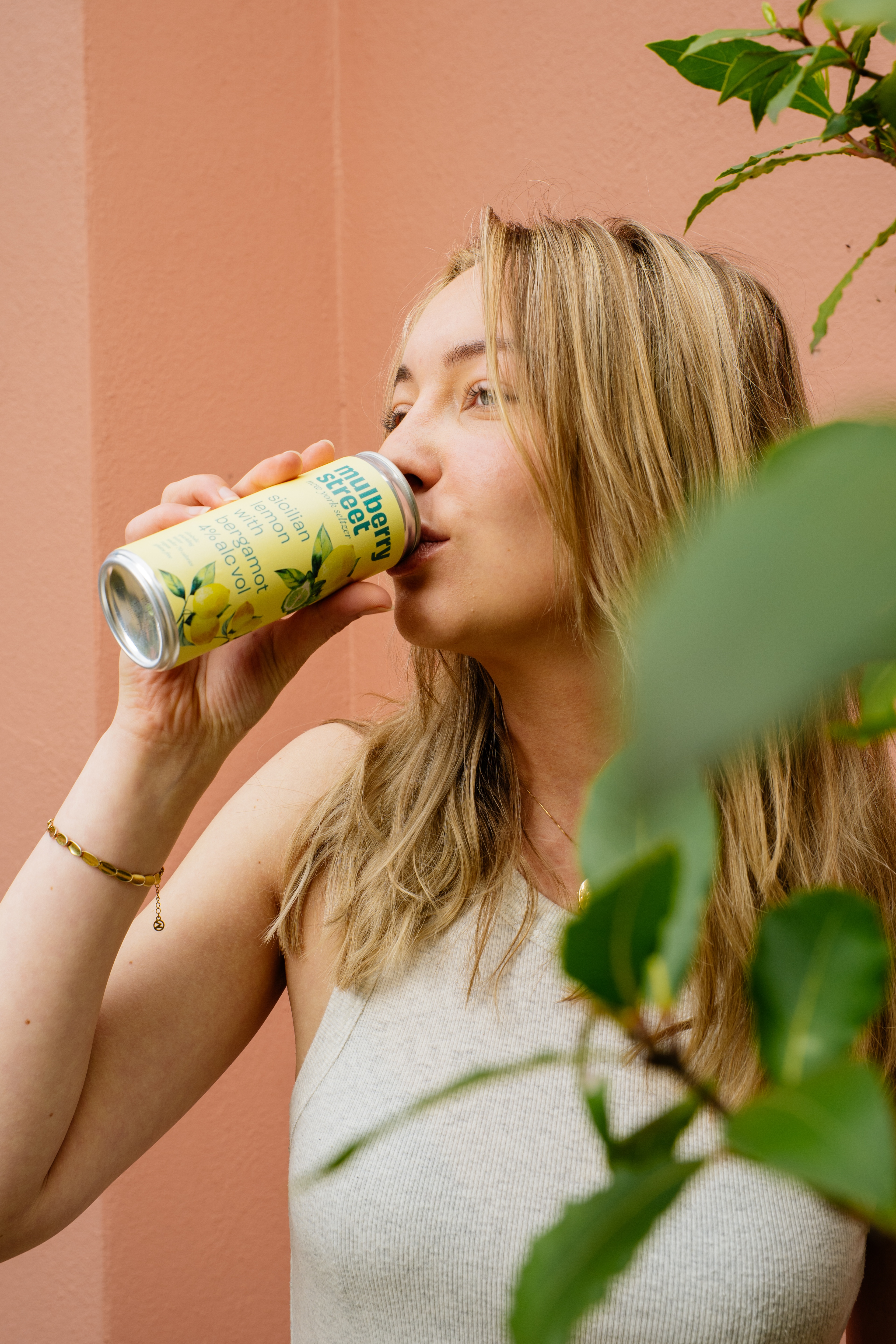 A person drinking from a can of Mulberry Street Lemon Seltzer
